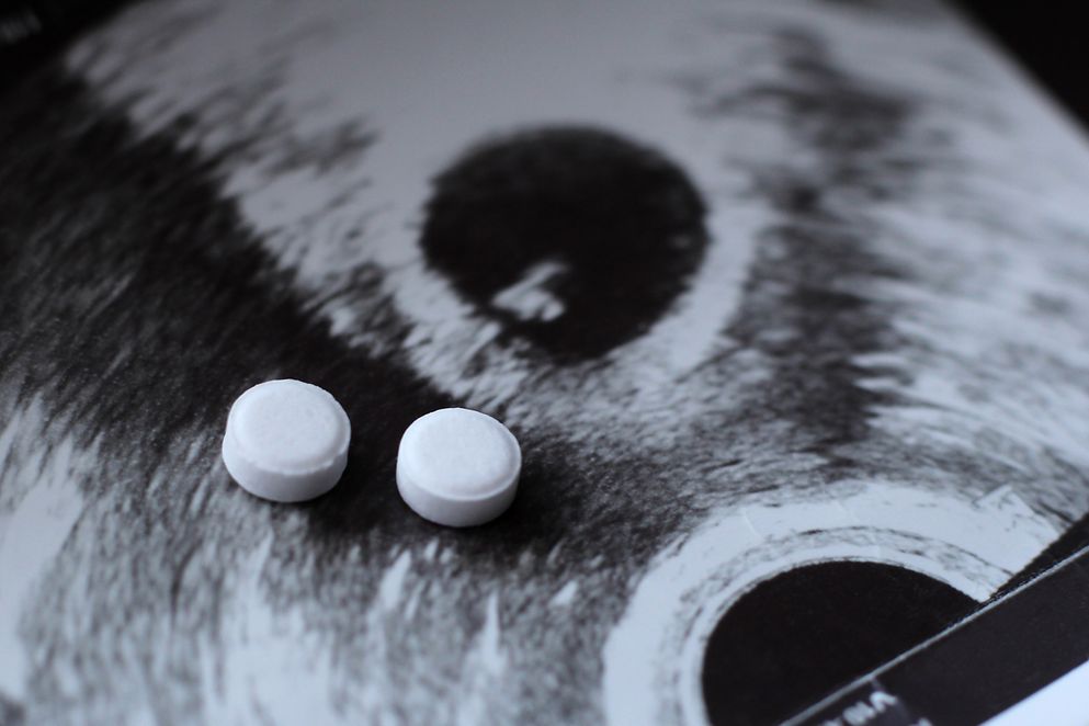 Ultraschall einer schwangeren Frau und Pillen