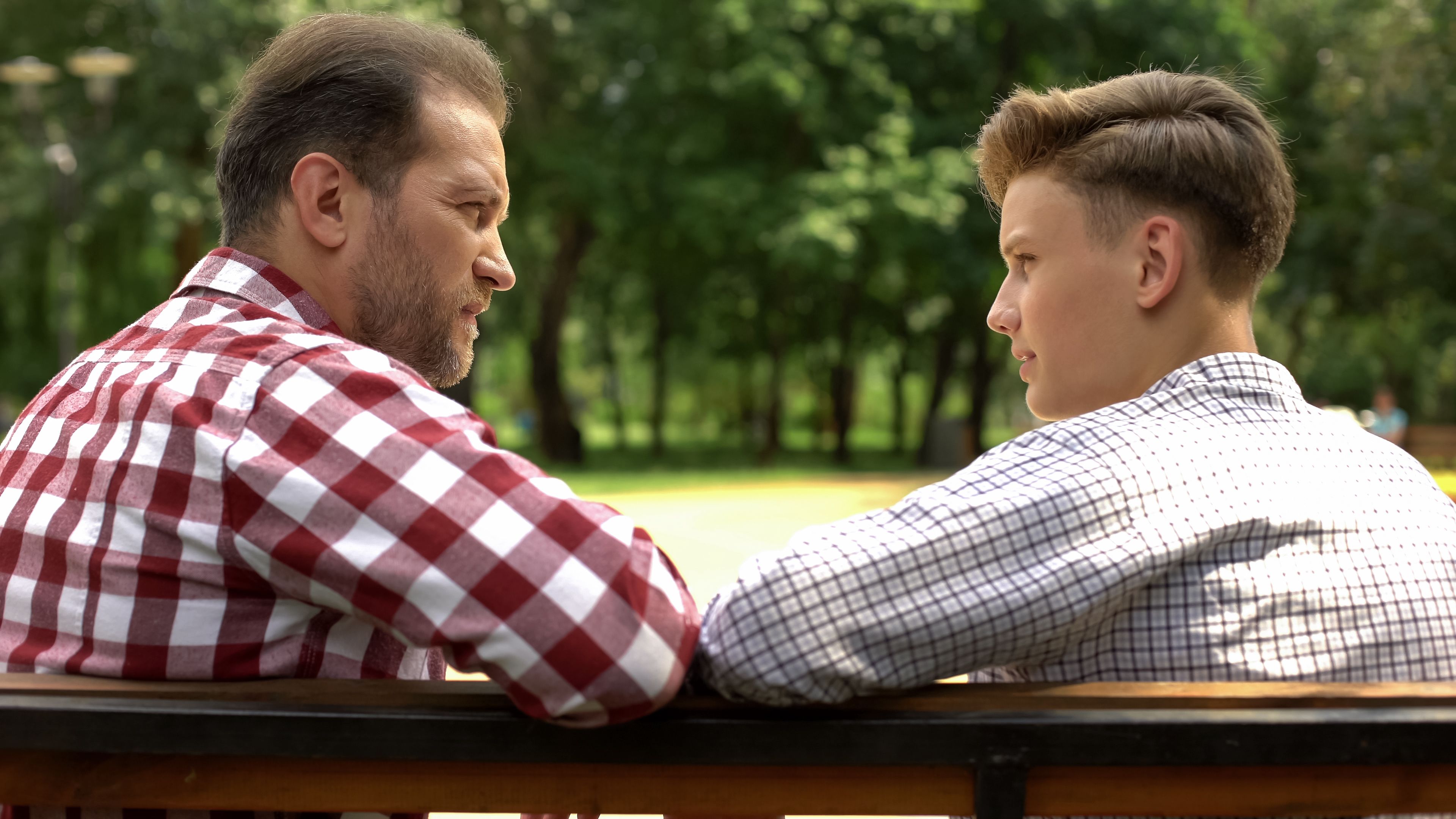 Ein Vater sitzt mit seinem Sohn auf einer Bank