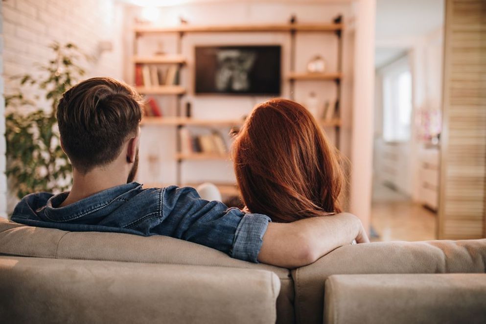 Ein Paar sitzt vor dem Fernseher